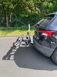 Fahrradträger für Auto, angebracht am Heck eines schwarzen Fahrzeugs.