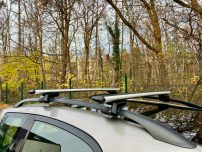 Dachträger eines Autos in einem Waldgebiet mit Bäumen im Hintergrund.