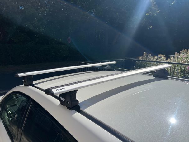 Dachträger aus Aluminium auf einem Auto, im Sonnenlicht beleuchtet.